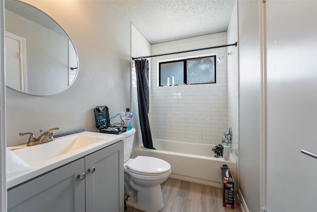 full bathroom with shower / bath combo, toilet, hardwood / wood-style floors, vanity, and a textured ceiling