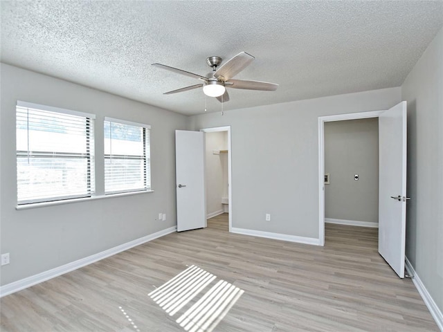 21401 Patton Ave Unit A & B, Lago Vista, TX 78645 - unfurnished bedroom with light wood-style flooring, a textured ceiling, baseboards, and ceiling fan