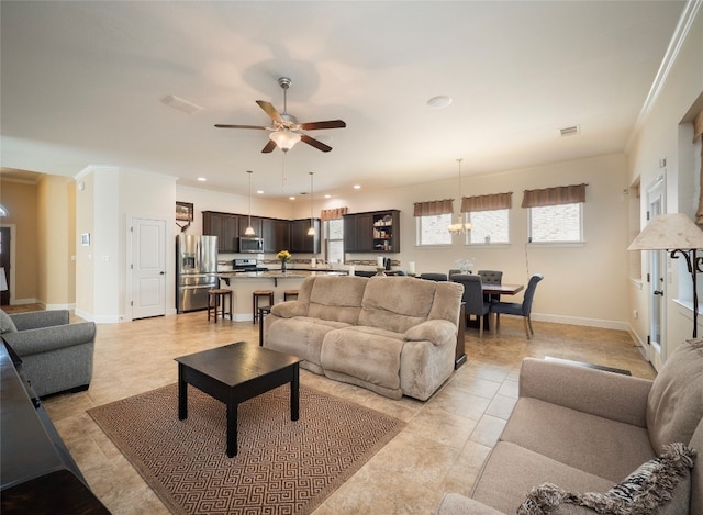 living room with ornamental molding, light tile patterned floors, and ceiling fan