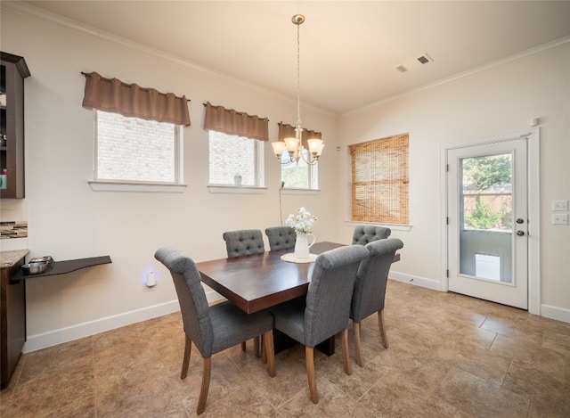 dining room featuring a notable chandelier, ornamental molding, and a healthy amount of sunlight