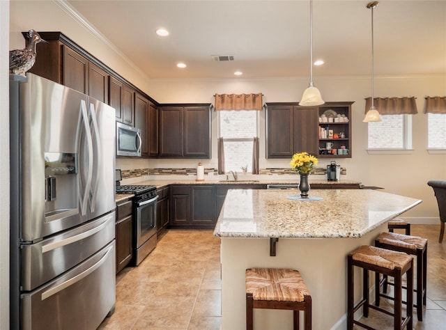 kitchen with a kitchen island, hanging light fixtures, stainless steel appliances, a breakfast bar, and light stone countertops