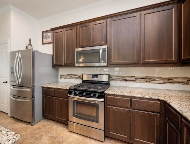 kitchen with tasteful backsplash, appliances with stainless steel finishes, dark brown cabinets, light stone counters, and ornamental molding