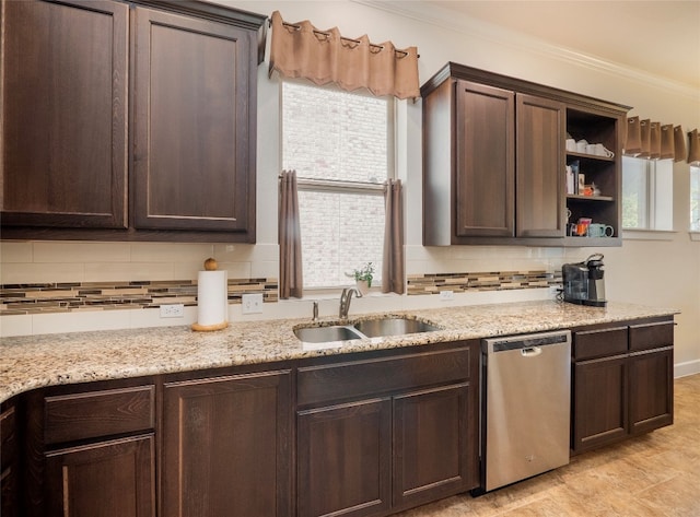 kitchen featuring tasteful backsplash, light stone countertops, sink, dark brown cabinetry, and stainless steel dishwasher