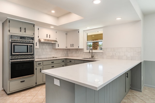 kitchen featuring kitchen peninsula, sink, black appliances, light tile patterned floors, and gray cabinets