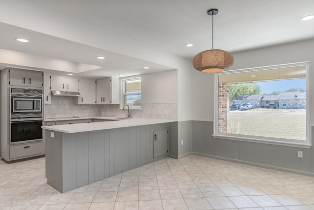 kitchen featuring black appliances, sink, kitchen peninsula, hanging light fixtures, and gray cabinets