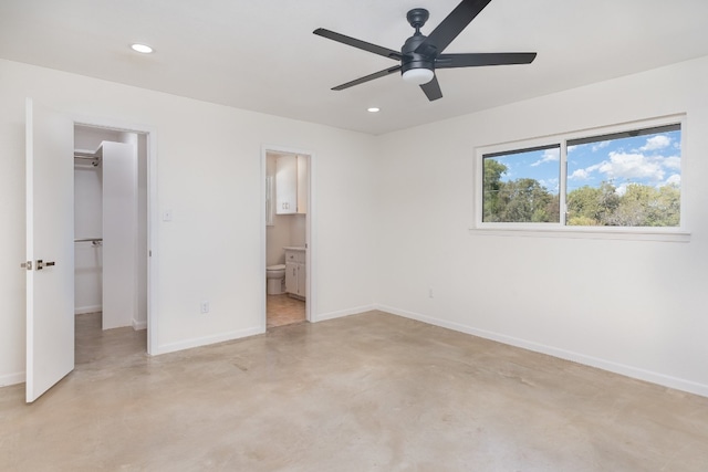 unfurnished bedroom with connected bathroom, ceiling fan, a closet, and a spacious closet