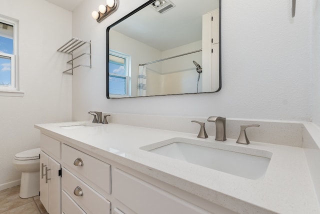 bathroom with toilet, a shower with curtain, vanity, and a wealth of natural light