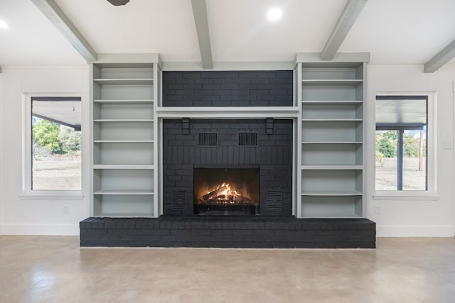 unfurnished living room featuring beamed ceiling, concrete flooring, a fireplace, and a healthy amount of sunlight