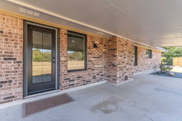 view of exterior entry featuring a patio area