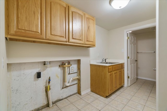 laundry room featuring sink, light tile patterned floors, cabinets, and washer hookup