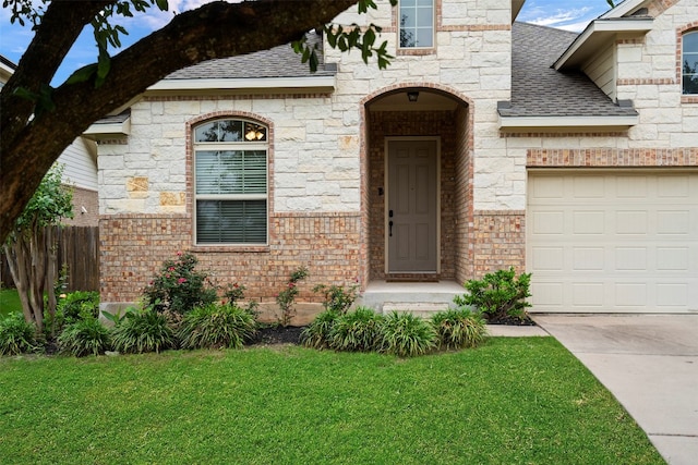 entrance to property with a garage and a lawn