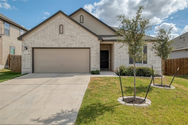 view of front facade with brick siding, concrete driveway, an attached garage, a front yard, and fence