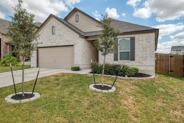 view of front of house featuring brick siding, a front yard, fence, a garage, and driveway