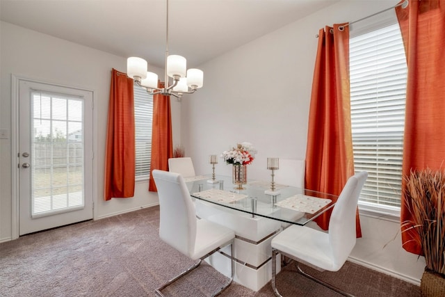 carpeted dining area featuring a chandelier