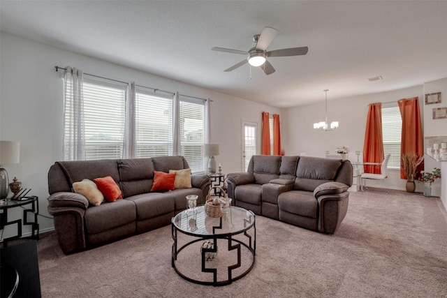 living area featuring baseboards, ceiling fan with notable chandelier, and light colored carpet