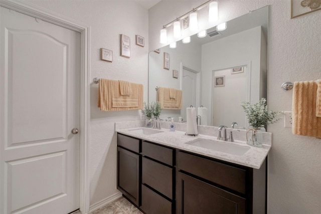 full bath featuring double vanity, a sink, and visible vents