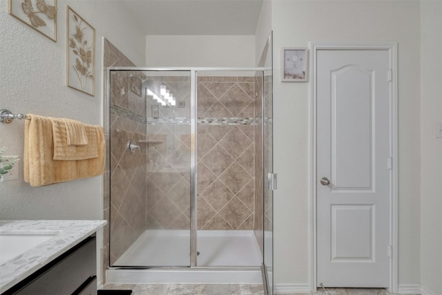 full bath with a stall shower and vanity