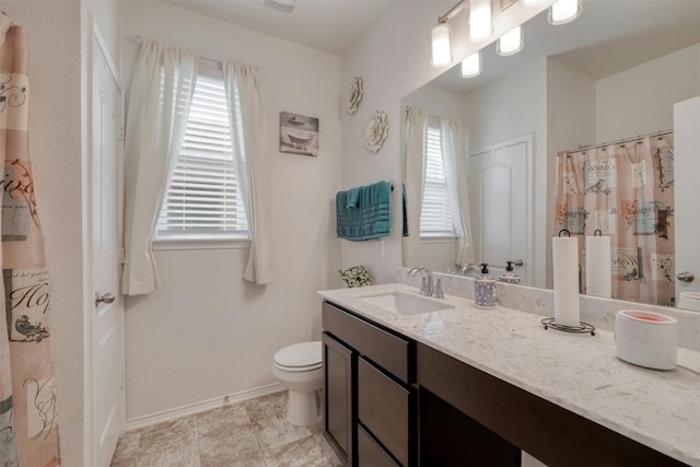 full bathroom featuring vanity, toilet, and baseboards