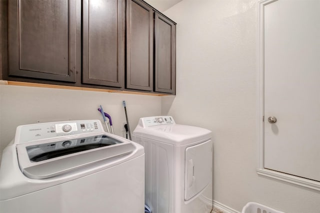 clothes washing area with independent washer and dryer and cabinet space