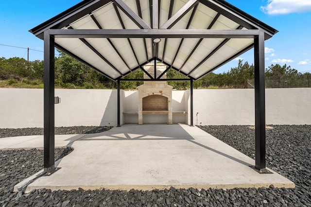 view of patio featuring a gazebo and an outdoor stone fireplace