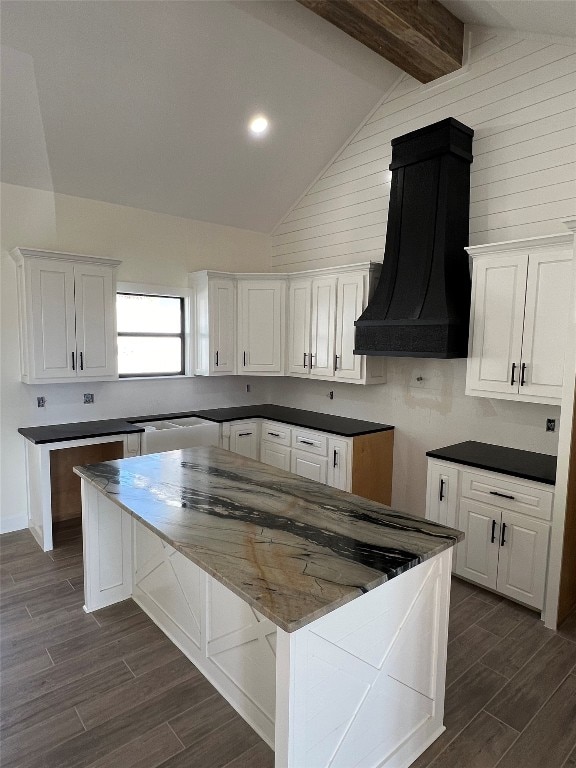 kitchen with dark hardwood / wood-style flooring, wooden walls, white cabinets, beam ceiling, and premium range hood