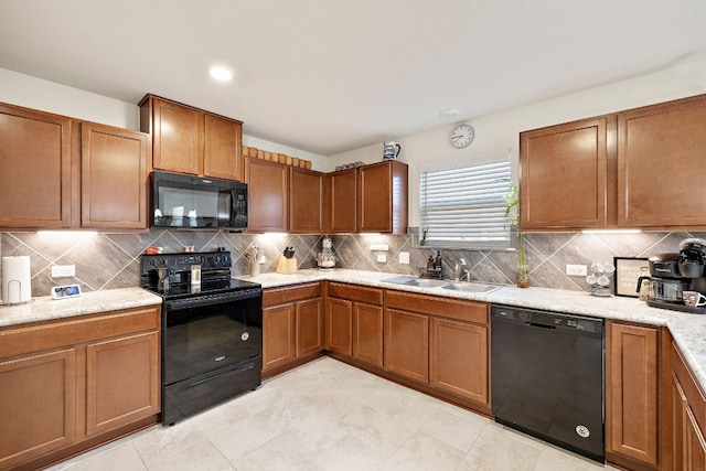 kitchen with sink, black appliances, light stone countertops, and backsplash