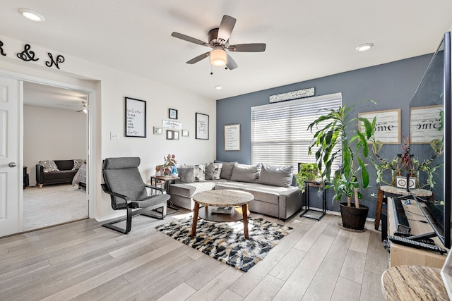 living room featuring light hardwood / wood-style flooring and ceiling fan