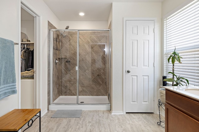 bathroom with a shower with door and vanity