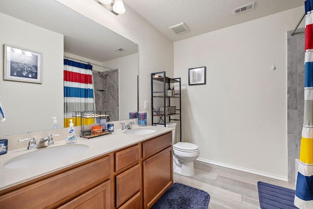 bathroom featuring a textured ceiling, hardwood / wood-style flooring, toilet, vanity, and a shower with shower curtain