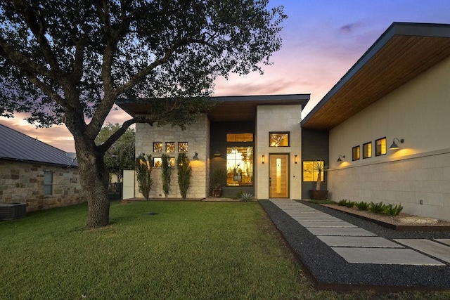 306 Fire Dance, Horseshoe Bay, TX 78657 - exterior entry at dusk featuring cooling unit and a yard