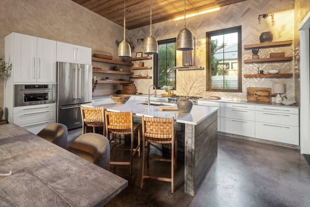 kitchen featuring sink, wooden ceiling, stainless steel appliances, decorative light fixtures, and white cabinets