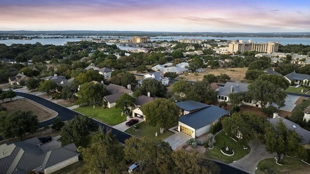 aerial view at dusk featuring a water view