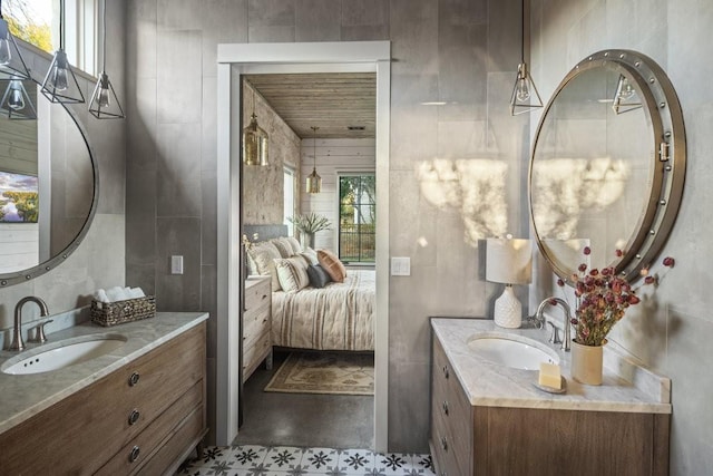 306 Fire Dance, Horseshoe Bay, TX 78657 - bathroom featuring healthy amount of natural light, two vanities, tile walls, and concrete flooring