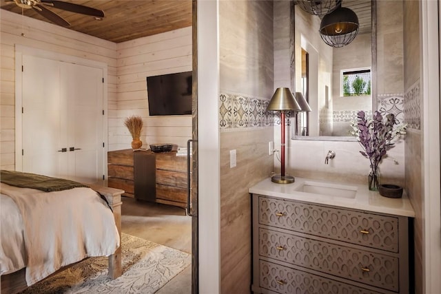 bedroom with wooden ceiling, sink, and wooden walls