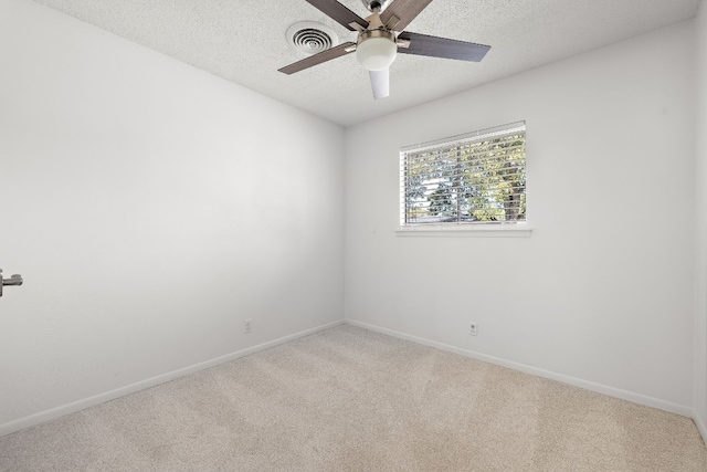 empty room with ceiling fan, carpet, and a textured ceiling