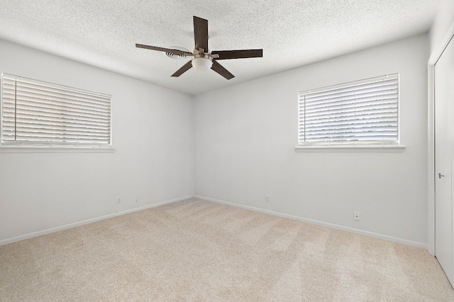 carpeted spare room with ceiling fan and a textured ceiling