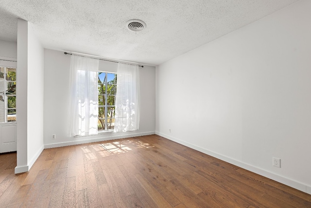 spare room with hardwood / wood-style floors and a textured ceiling