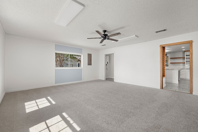 carpeted empty room with a textured ceiling, electric panel, and ceiling fan