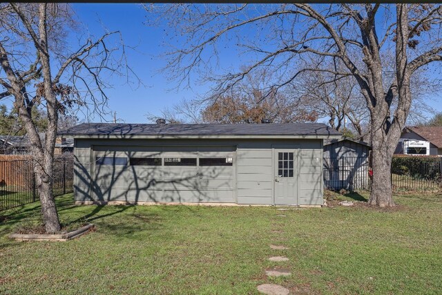 view of outdoor structure with a garage and a lawn