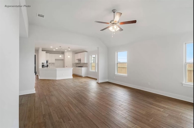 unfurnished living room featuring lofted ceiling, hardwood / wood-style flooring, sink, and ceiling fan