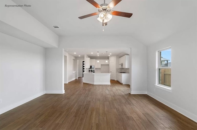 unfurnished living room featuring ceiling fan, vaulted ceiling, and dark hardwood / wood-style flooring