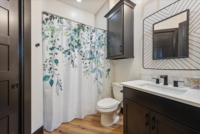 bathroom featuring vanity, wood-type flooring, toilet, and walk in shower