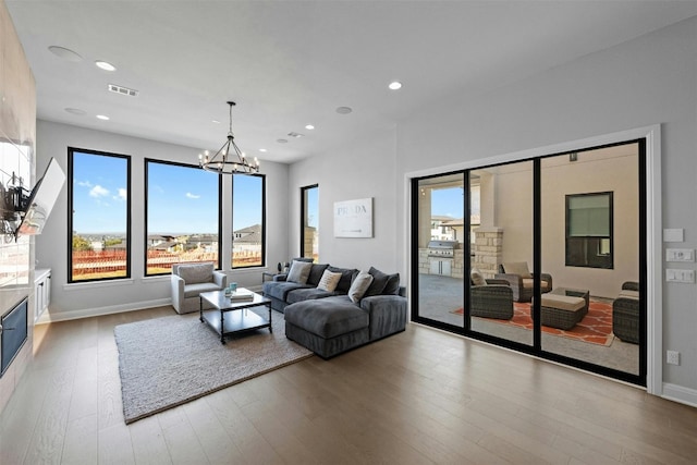 living room featuring a wealth of natural light, a chandelier, and hardwood / wood-style flooring