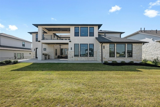 back of house featuring a lawn, ceiling fan, a balcony, and a patio