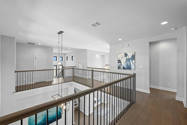 hallway featuring dark hardwood / wood-style floors and an inviting chandelier