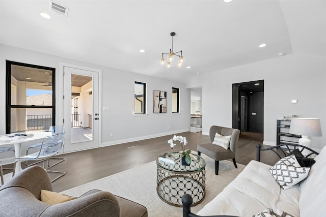 living room featuring a chandelier, hardwood / wood-style floors, and vaulted ceiling