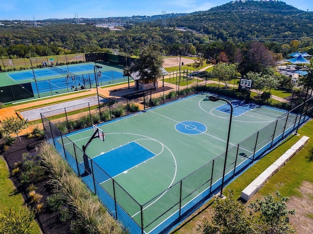 view of sport court featuring a mountain view and tennis court