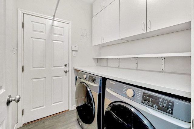 washroom with washer and clothes dryer, light hardwood / wood-style floors, and cabinets