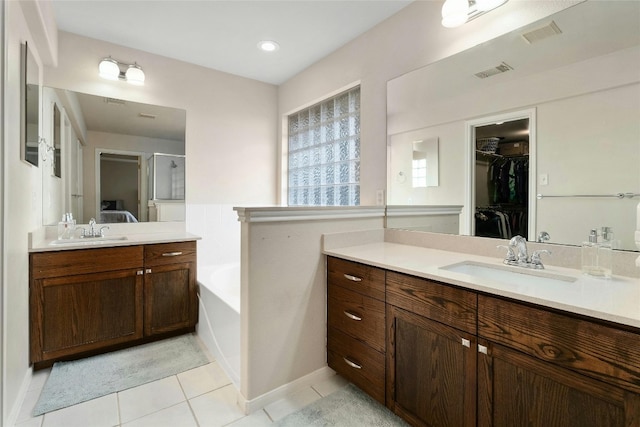 bathroom featuring a sink, visible vents, two vanities, and a bath