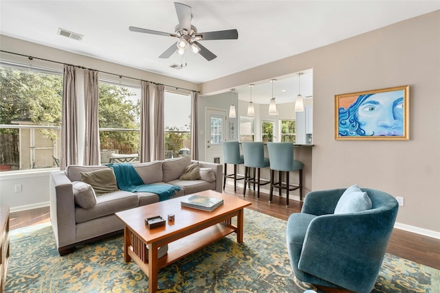 living room with ceiling fan and dark hardwood / wood-style flooring